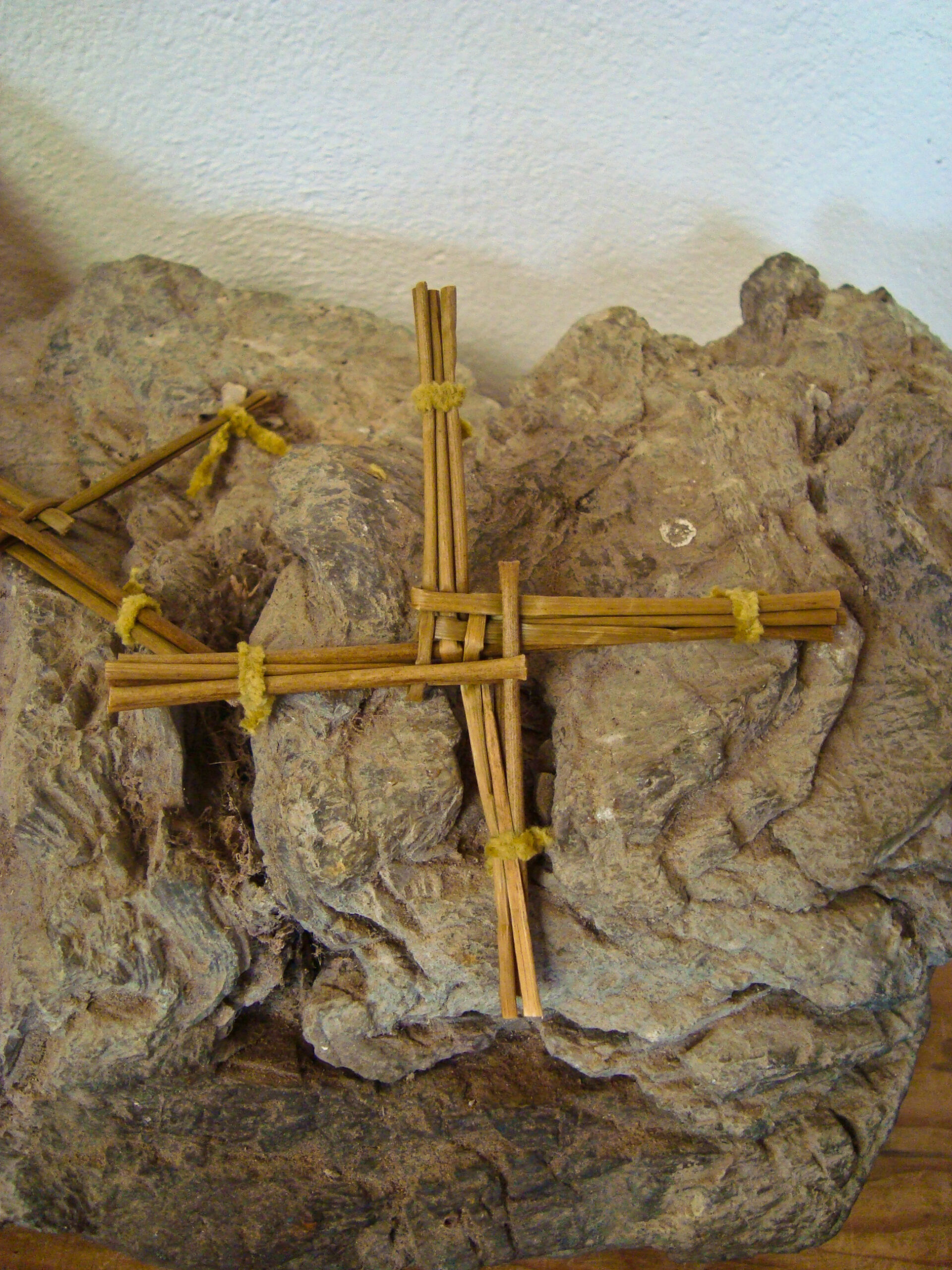 A traditional Saint Brigid's Cross, woven from rushes, mounted on stone