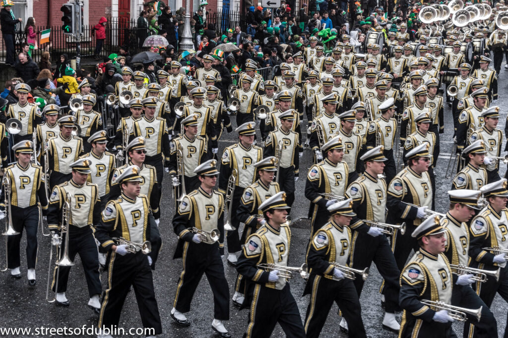 Crowds in green and Irish tricolour flags watch a marching band parade down a Dublin street during the St Patrick's Festival