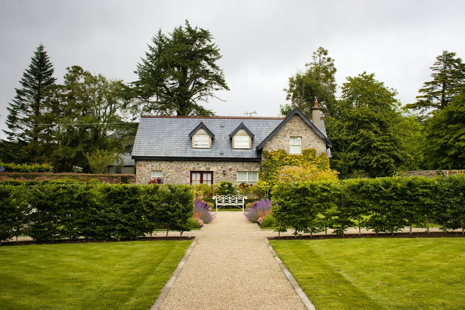 A stone cottage with a walled garden and gravel path in the Irish countryside