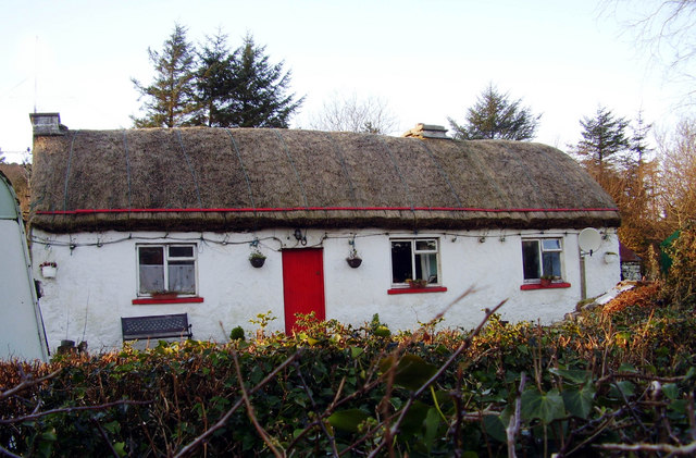 A whitewashed thatched cottage with a red door in Ardara, County Donegal &mdash; the kind of rural Irish home where a Stations Mass would be held