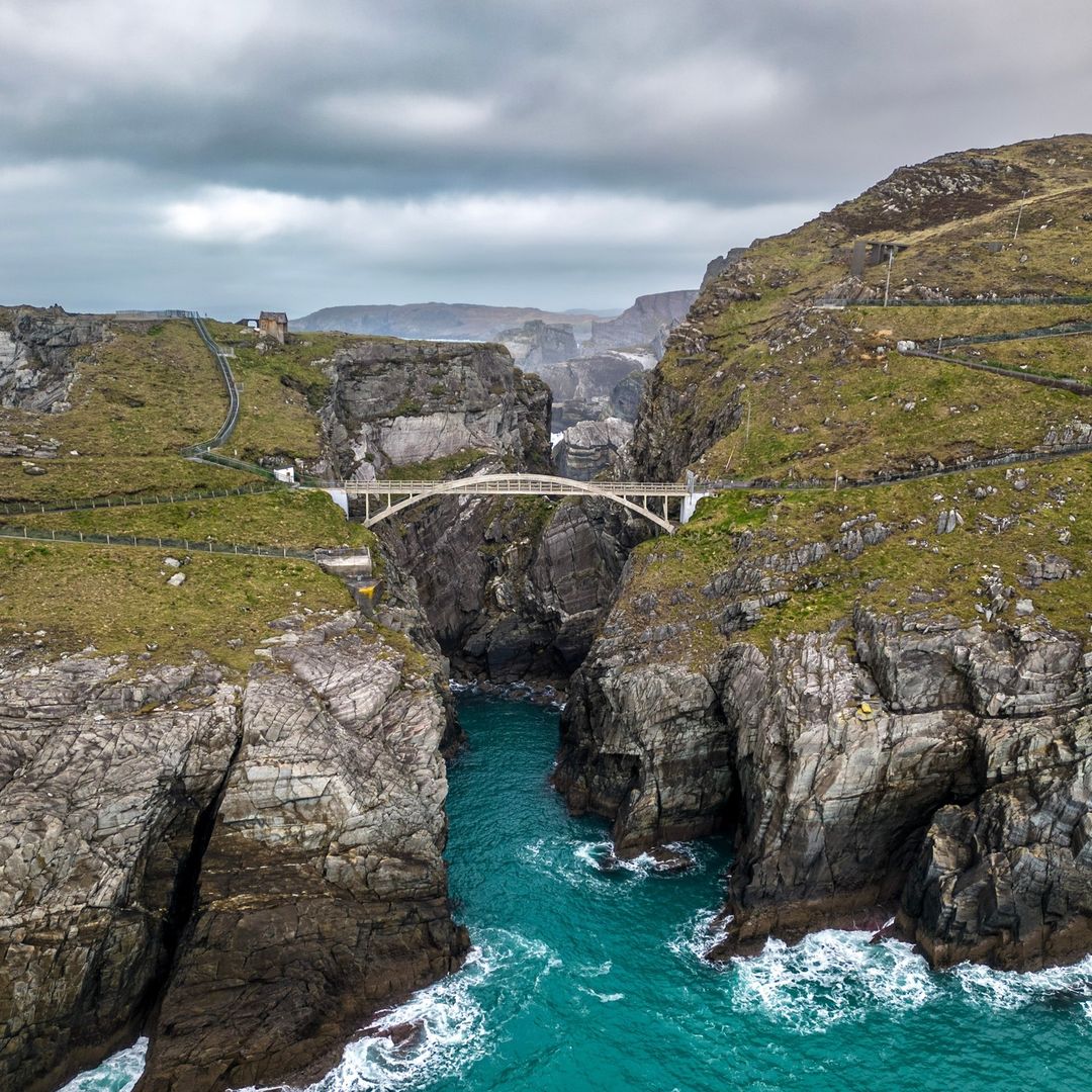 Aerial view of Mizen Head Bridge, a concrete arch bridge spanning a rocky Atlantic chasm in West Cork, Ireland