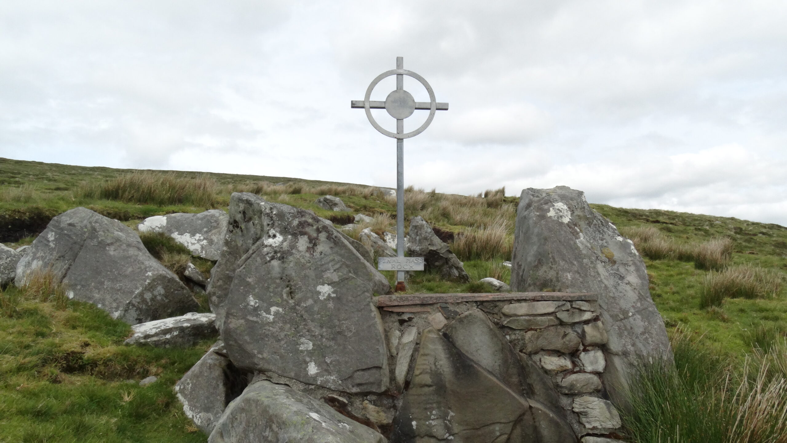 A Penal-era Mass rock memorial on the southern slope of Bengorm, Co. Mayo, with a stone cross marking the hidden altar where Catholics worshipped in secret during the Penal Laws