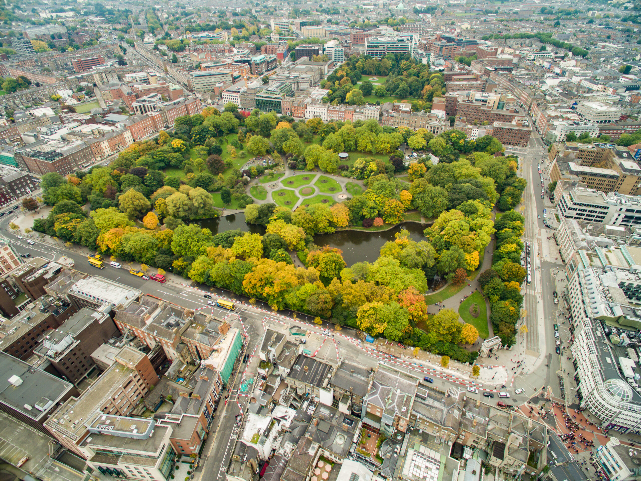 Aerial view of St Stephen's Green in Dublin, showing the geometric flower beds, central lake, and surrounding Georgian streets