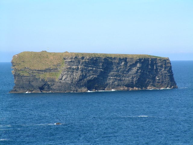 Bishop's Island, a flat-topped sea stack off the Kilkee coast in County Clare, with the ruins of a 6th-century monastery visible on top