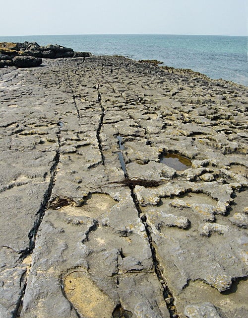 Cracked grey limestone pavement with deep grikes on the Burren coastline