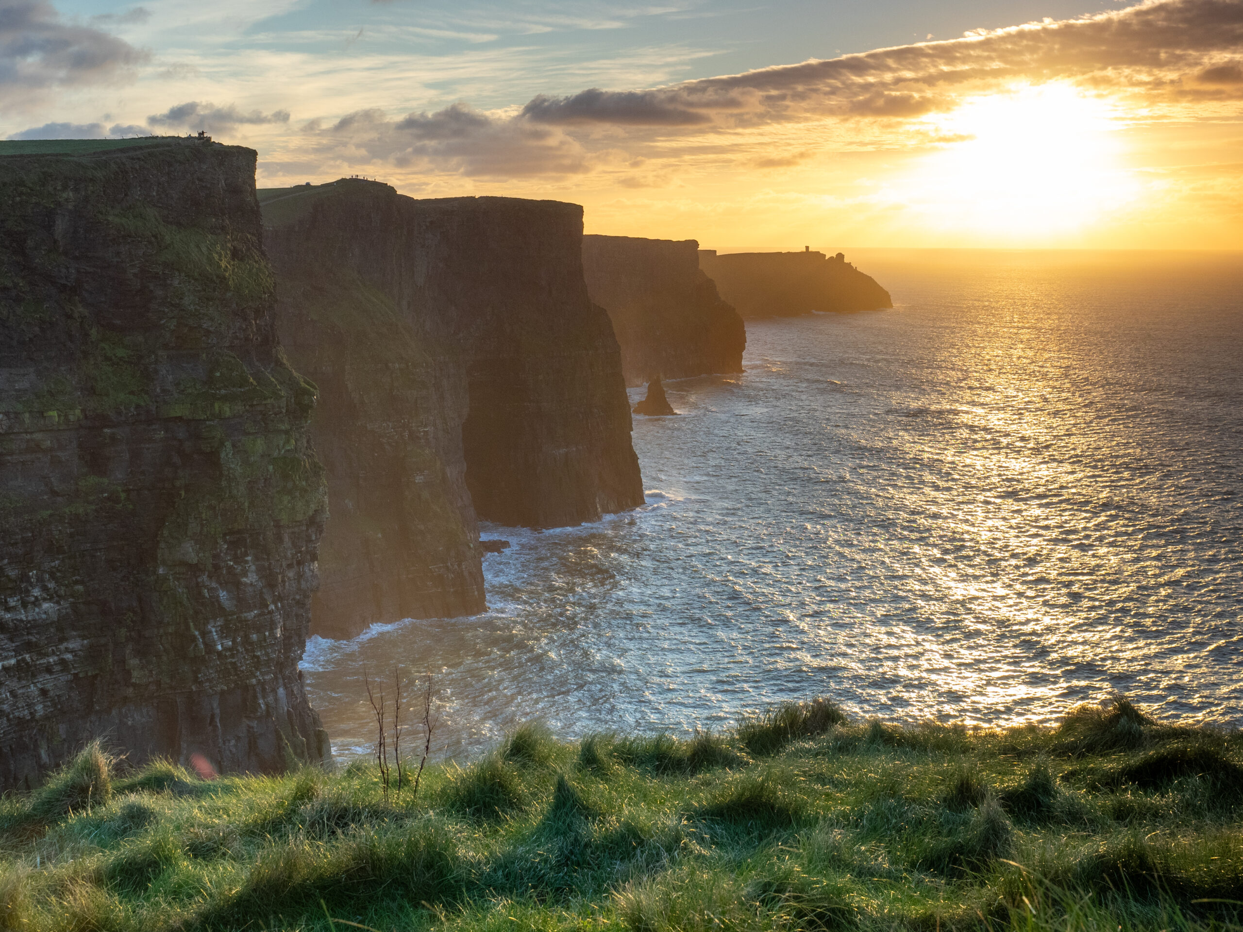 Sunset over the Cliffs of Moher, County Clare, with O'Brien's Tower visible on the headland in the distance