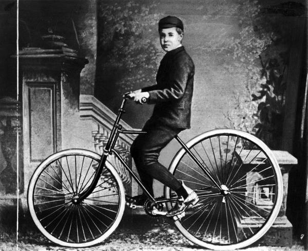 A young cyclist riding an 1890s safety bicycle fitted with early pneumatic tyres