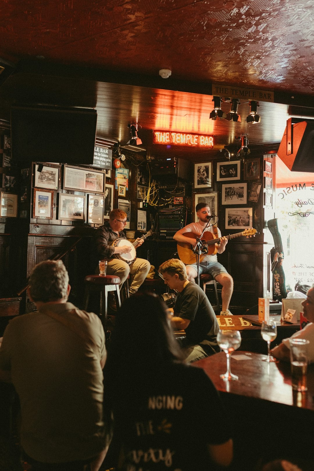 Musicians playing banjo and guitar during a live traditional Irish music session at The Temple Bar pub in Dublin