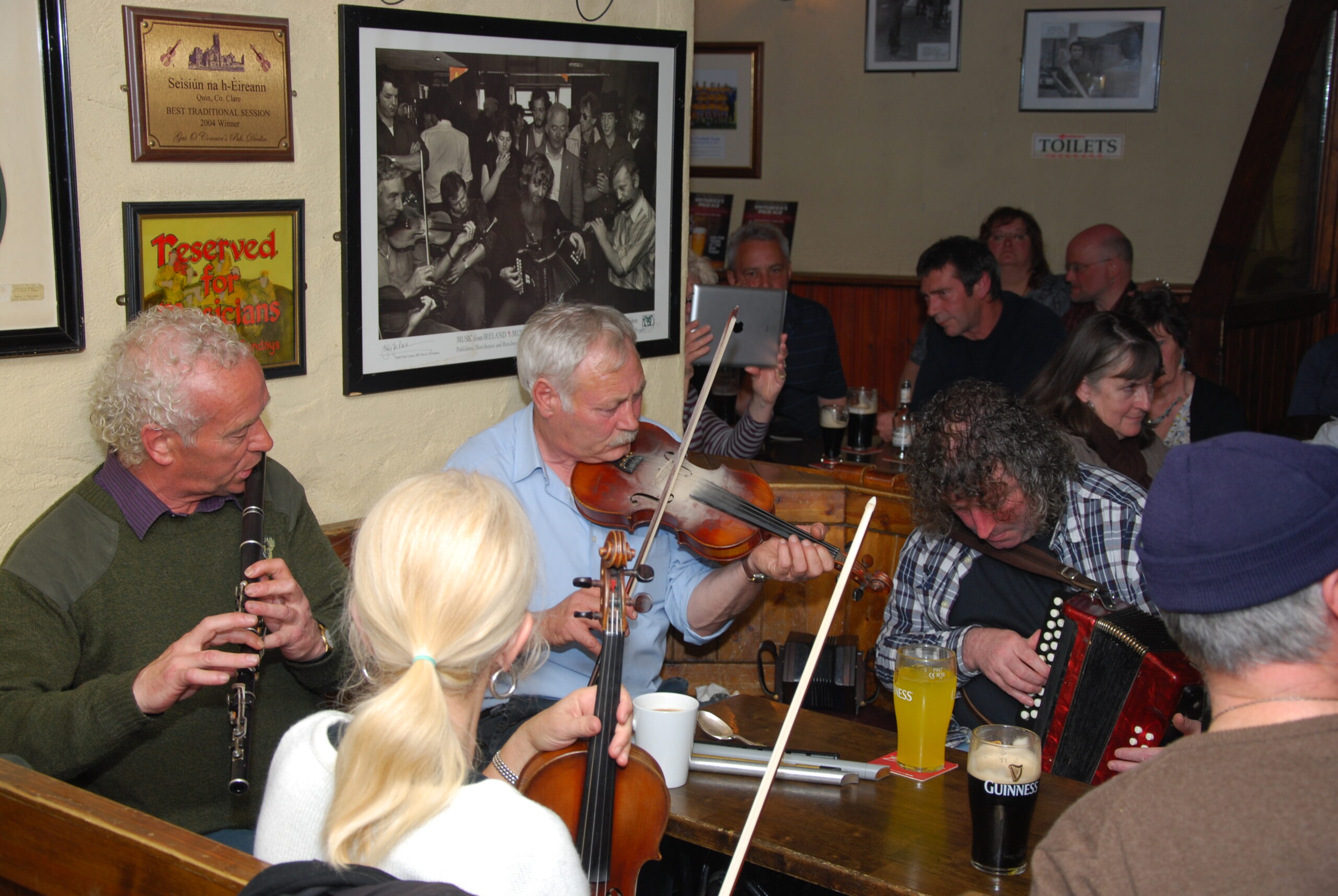 Musicians playing fiddle, flute and accordion at a traditional Irish music session in Gus O'Connor's pub, Doolin, County Clare
