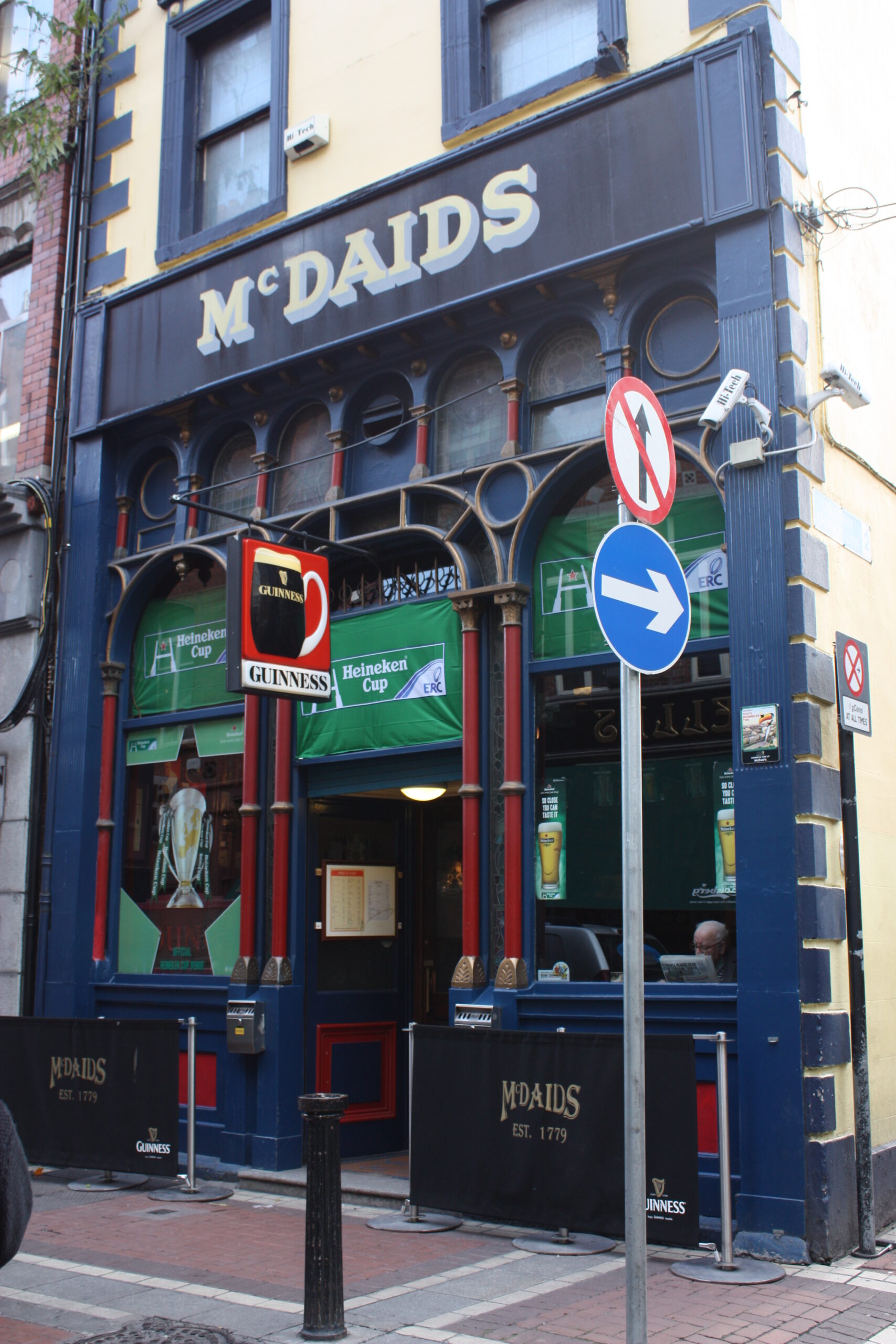 McDaid's pub exterior on Harry Street, Dublin, with its distinctive dark blue Victorian shopfront and Guinness sign