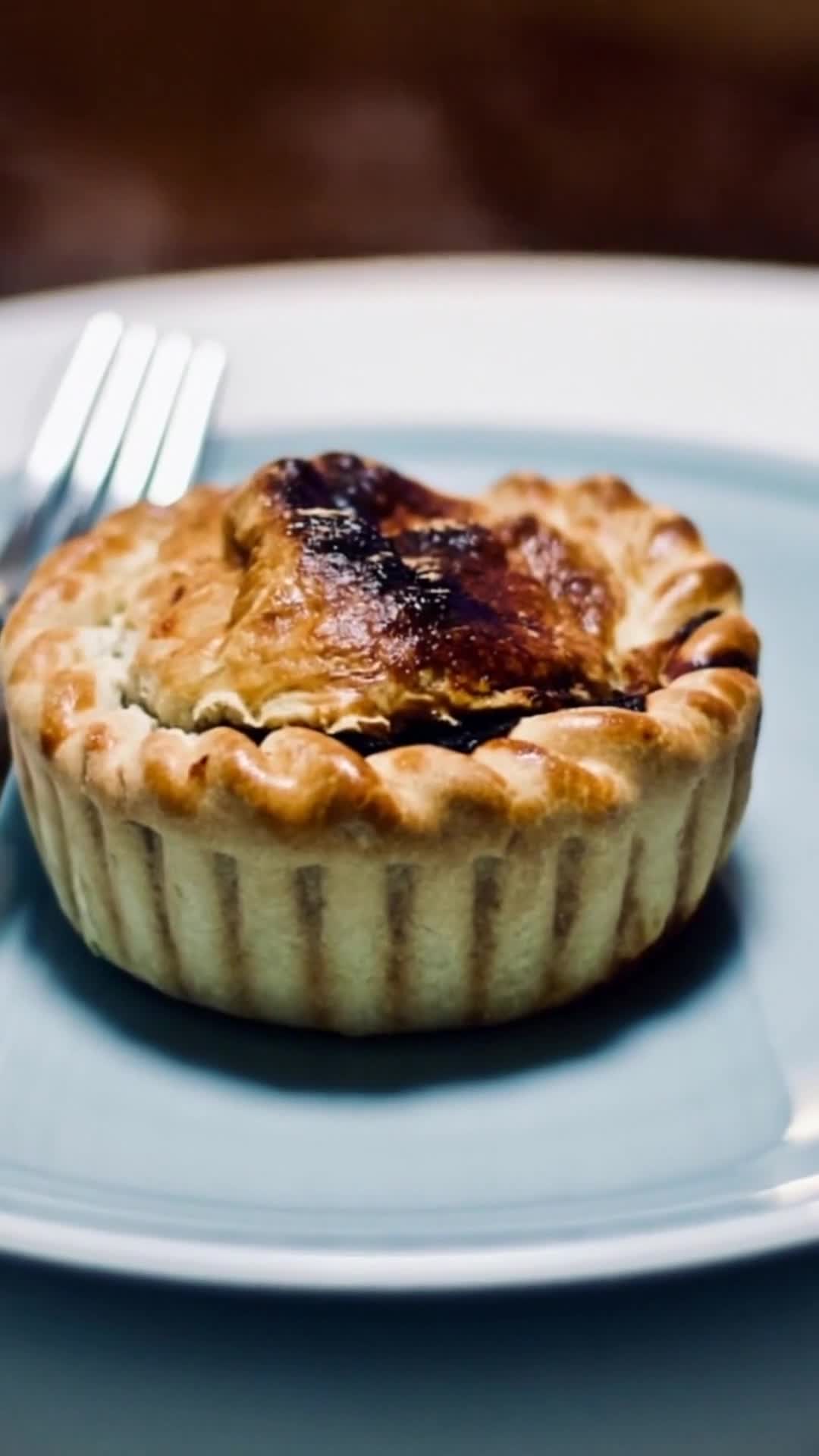 Golden-crusted beef and Guinness pie in a fluted pastry case on a plate, ready to be served
