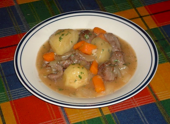 Bowl of traditional white Irish lamb stew with tender lamb, potatoes, and carrots in a pale broth, garnished with parsley