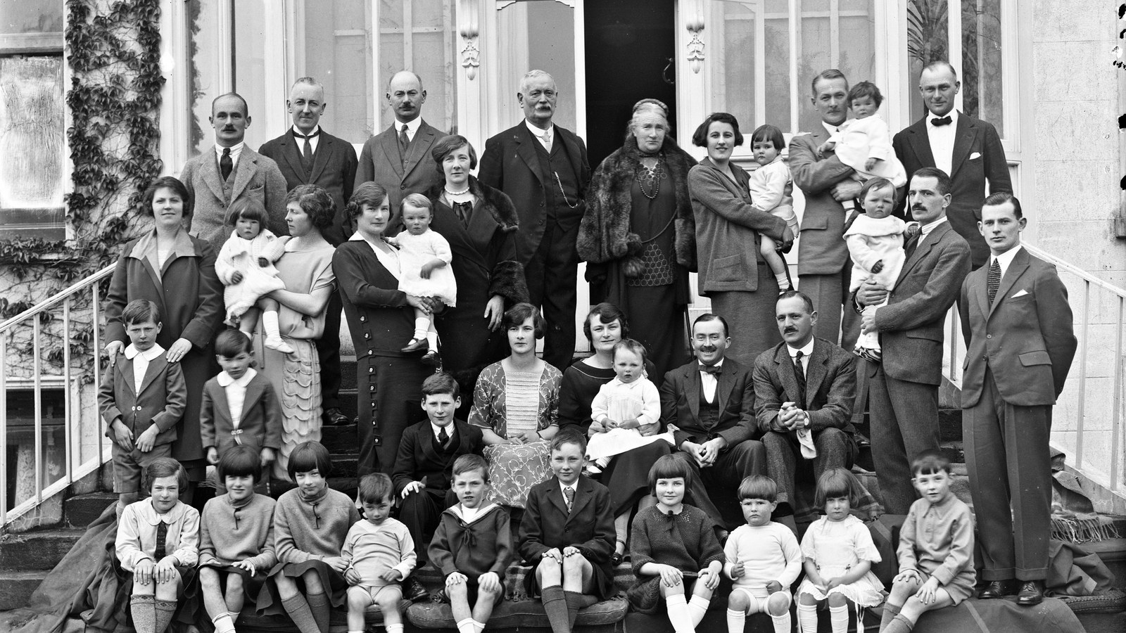 A large Irish family photographed on the steps of a house about a century ago