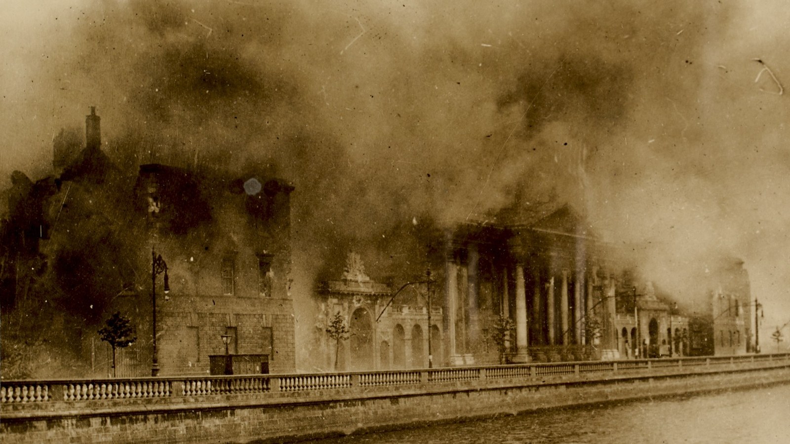 The Four Courts in Dublin burning on 30 June 1922, smoke over the building beside the River Liffey