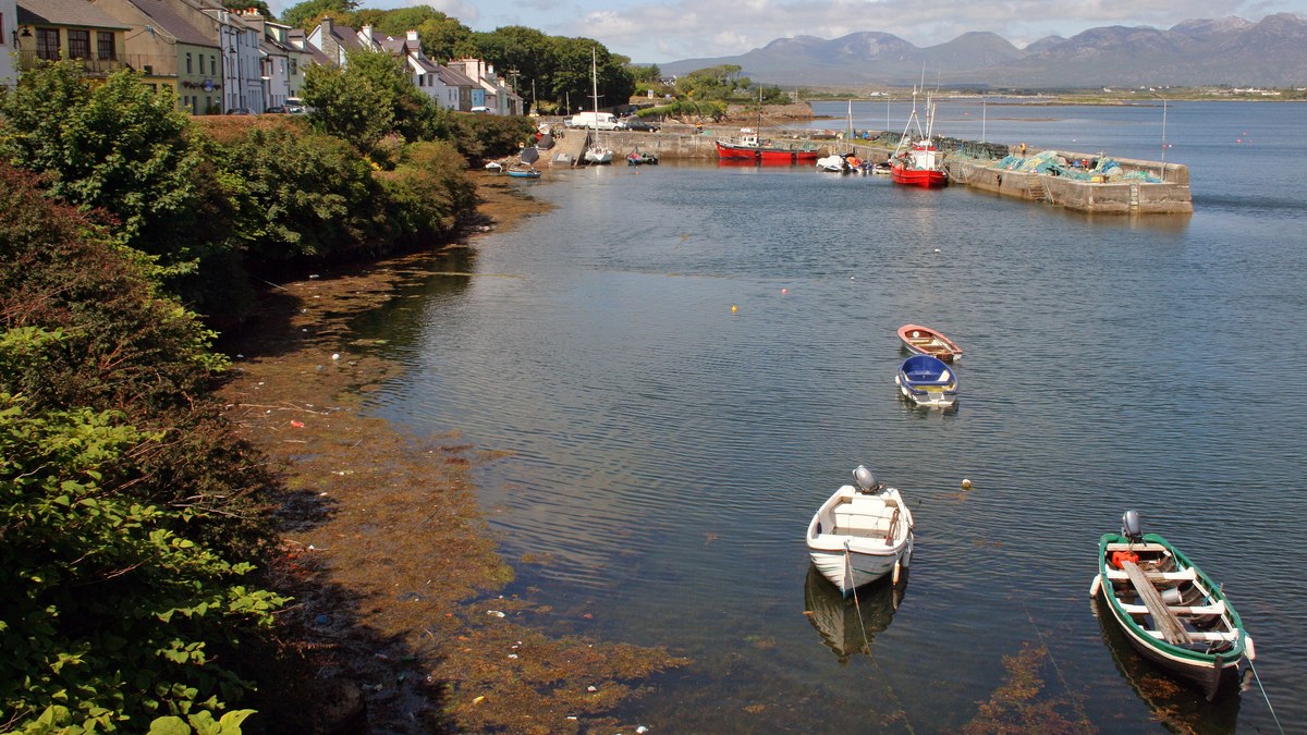 Small boats in Roundstone harbour, Connemara, with the village and the Twelve Bens behind