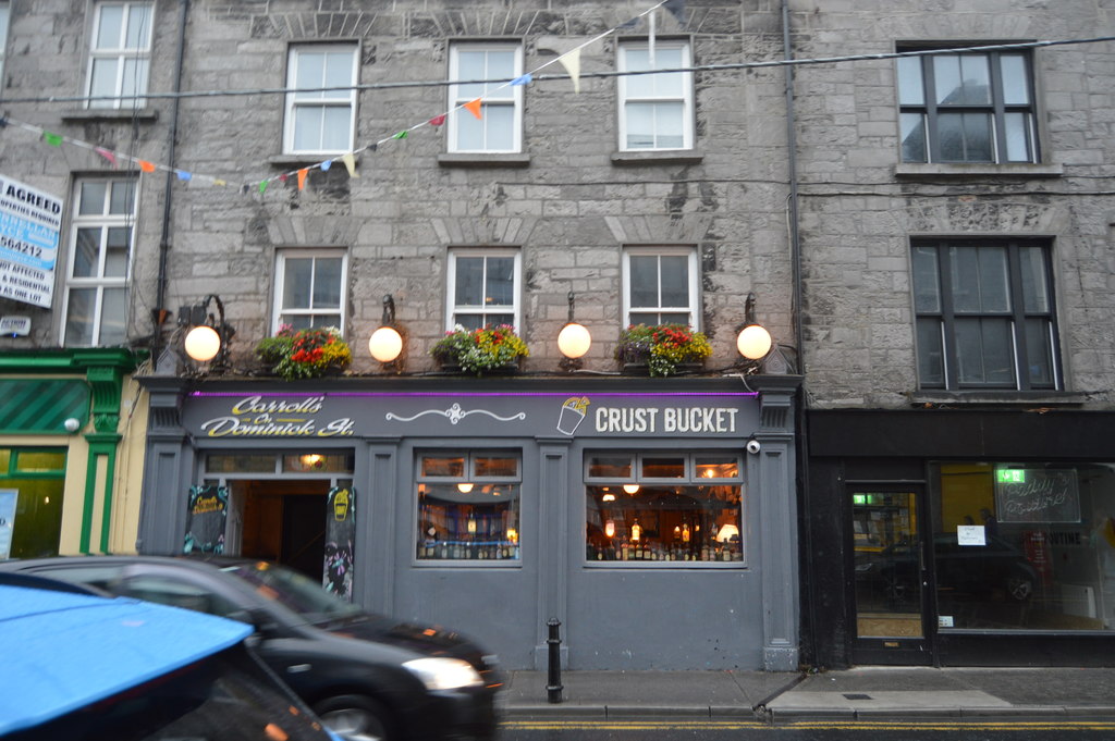 Carroll's Bar on Dominick Street Lower in Galway's West End, with the Crust Bucket pizza sign and bunting over the entrance
