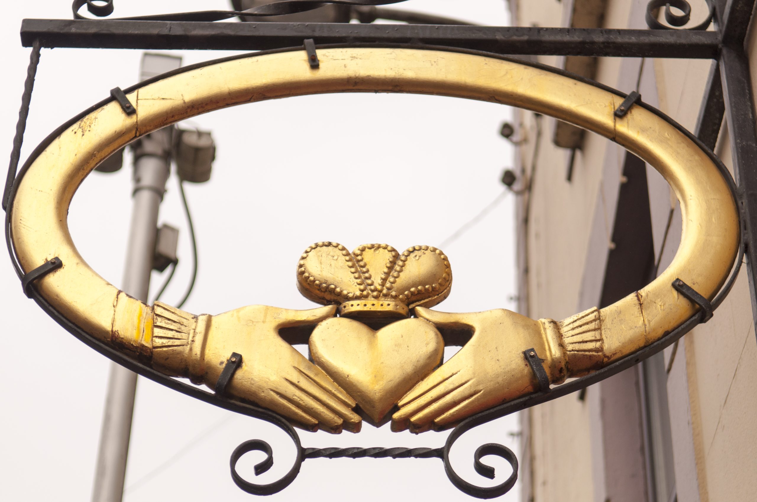 Golden Claddagh ring sign in Galway, showing the two hands holding a crowned heart