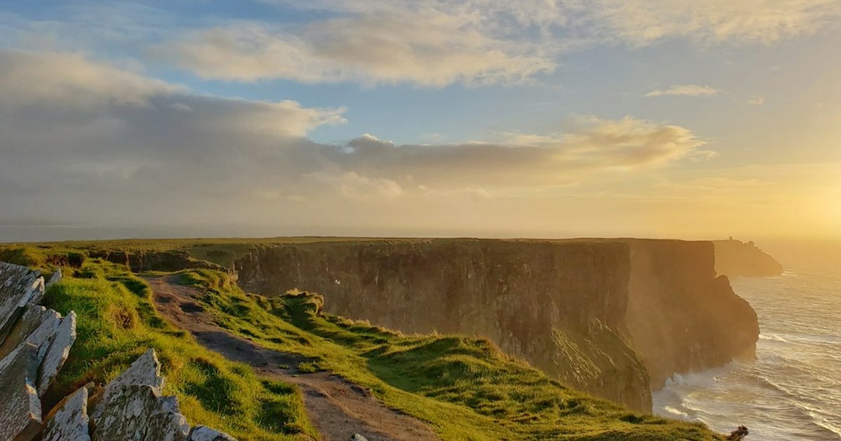 Sunset over the Cliffs of Moher, County Clare, with O'Brien's Tower visible on the headland in the distance
