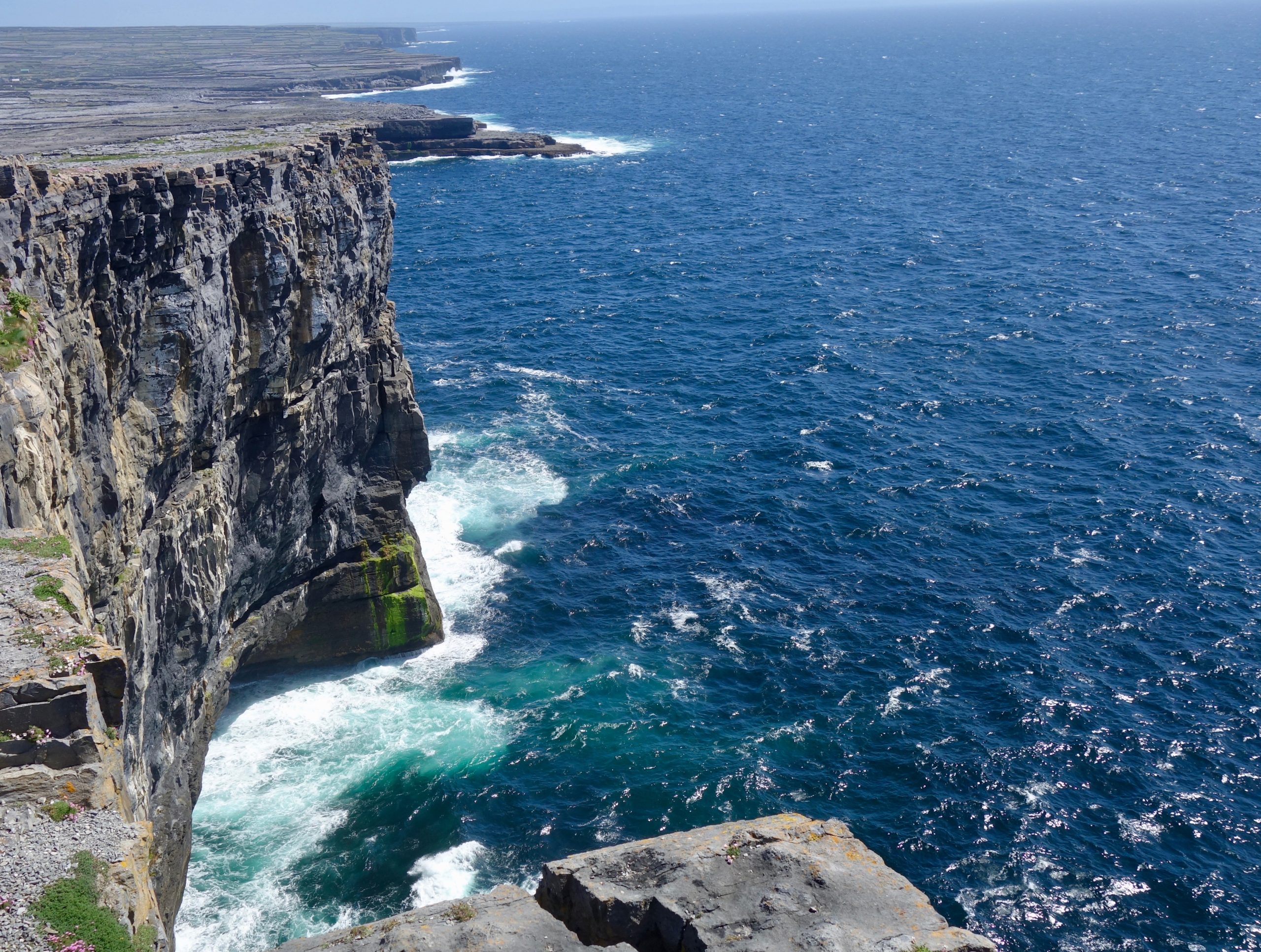 View along the sheer cliff edge at Dún Aonghasa fort on Inis Mór, Aran Islands, with Atlantic waves breaking below