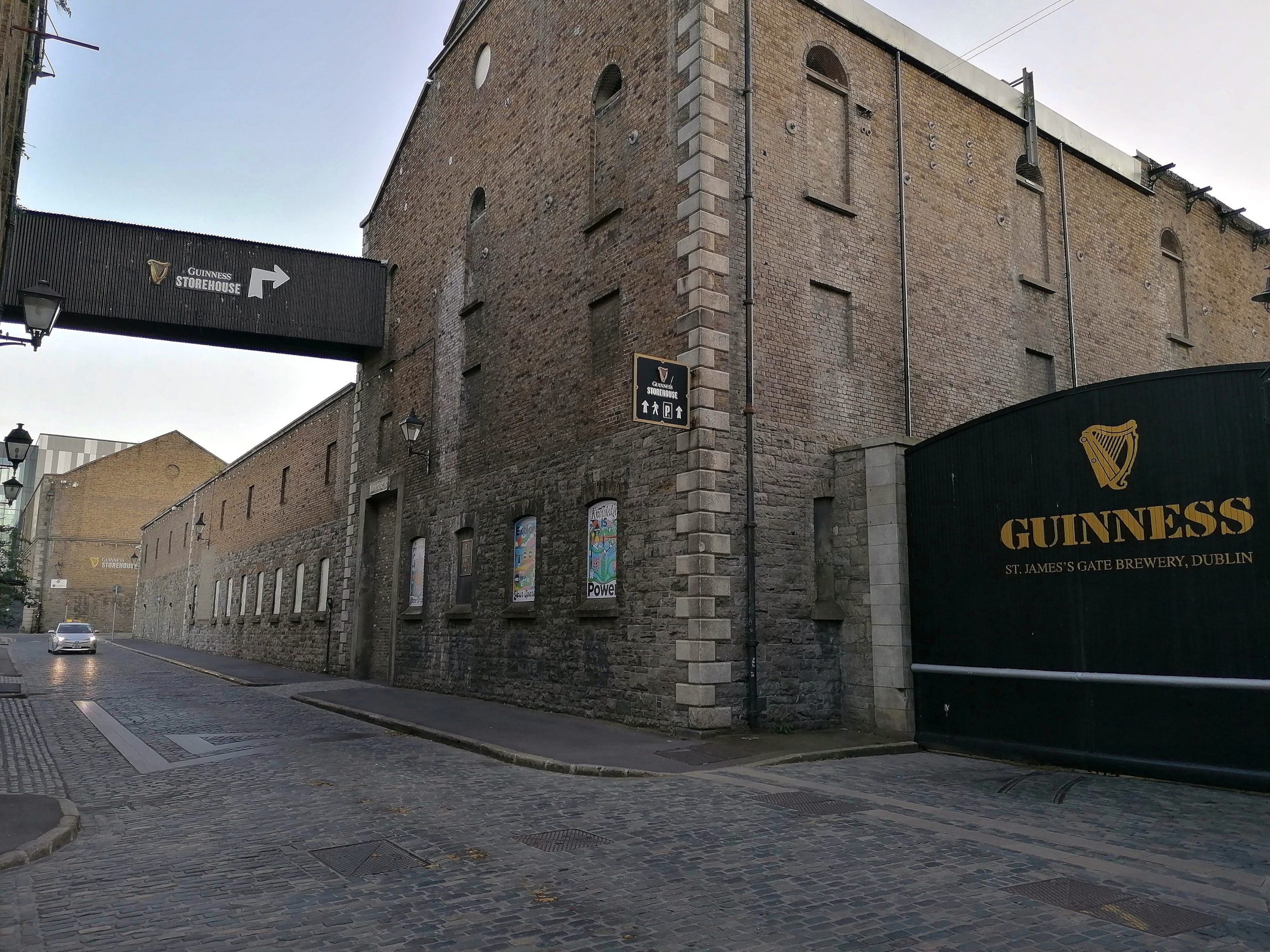 Guinness St James's Gate Brewery wall and Guinness Storehouse signage on a cobbled street in Dublin