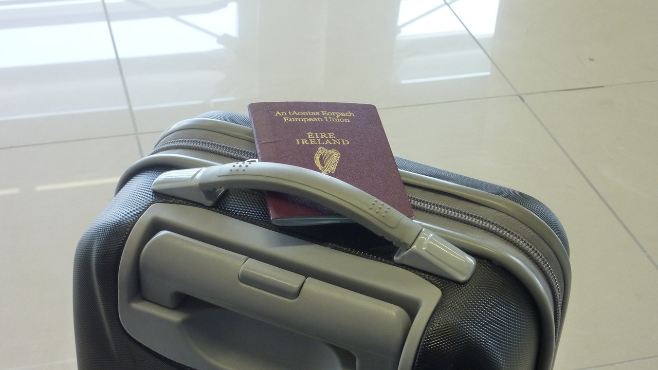 An Irish passport resting on a suitcase at an airport