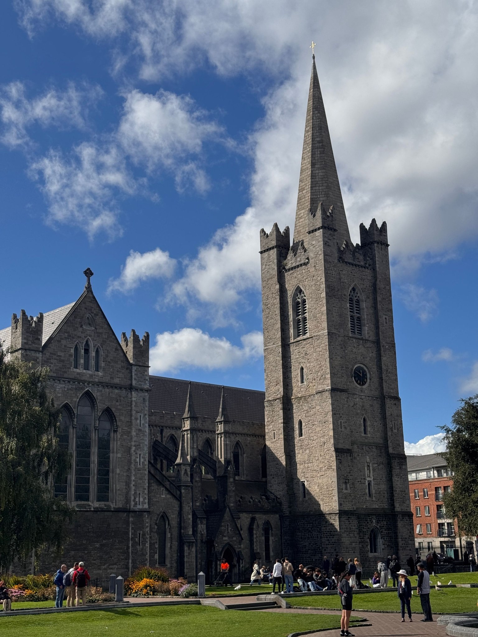 St Patrick's Cathedral, Dublin, with its tall stone spire, seen from the park on a sunny day