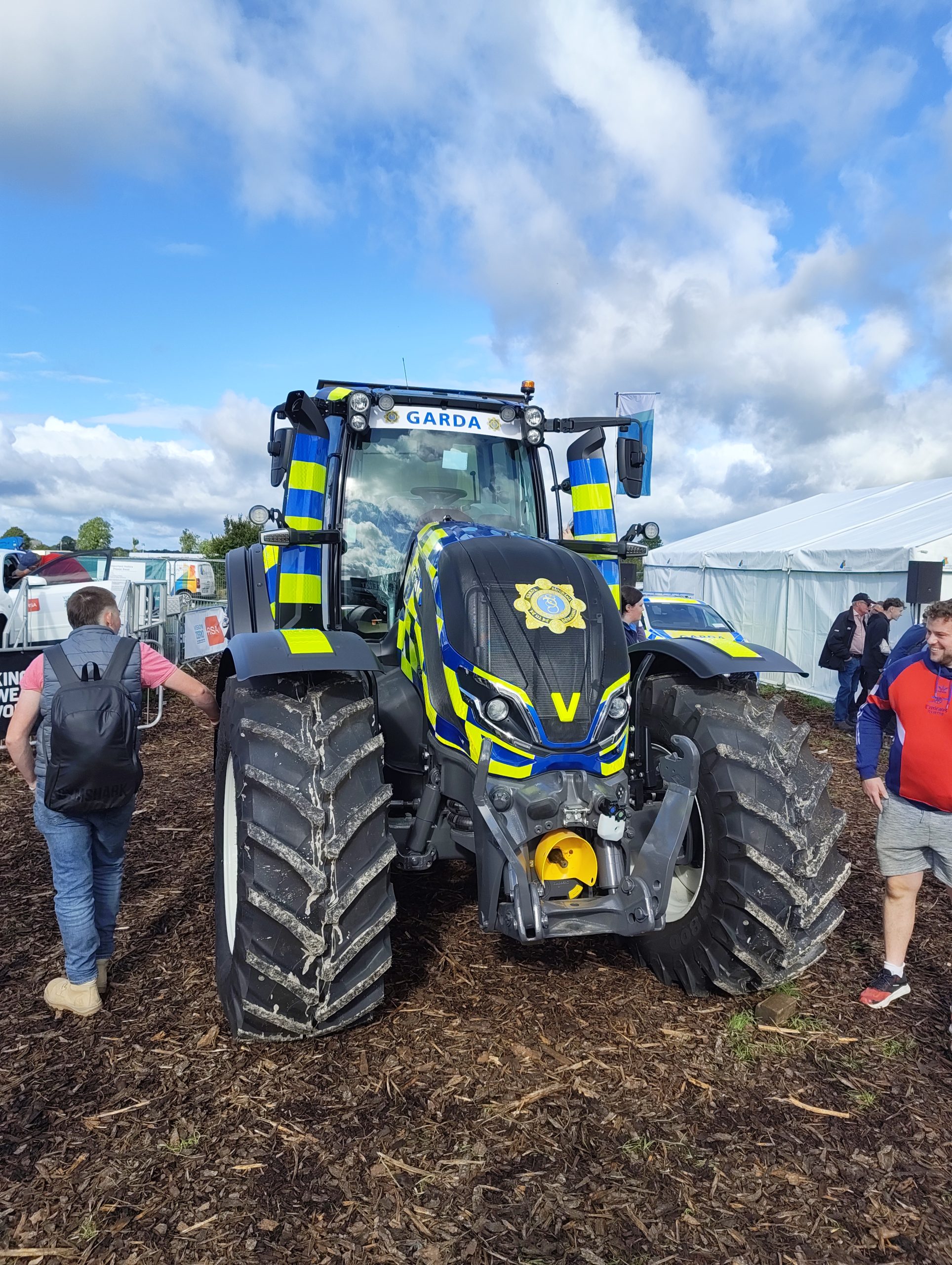 A Garda-liveried tractor on display at the National Ploughing Championships in Screggan, Co. Offaly, with visitors walking past