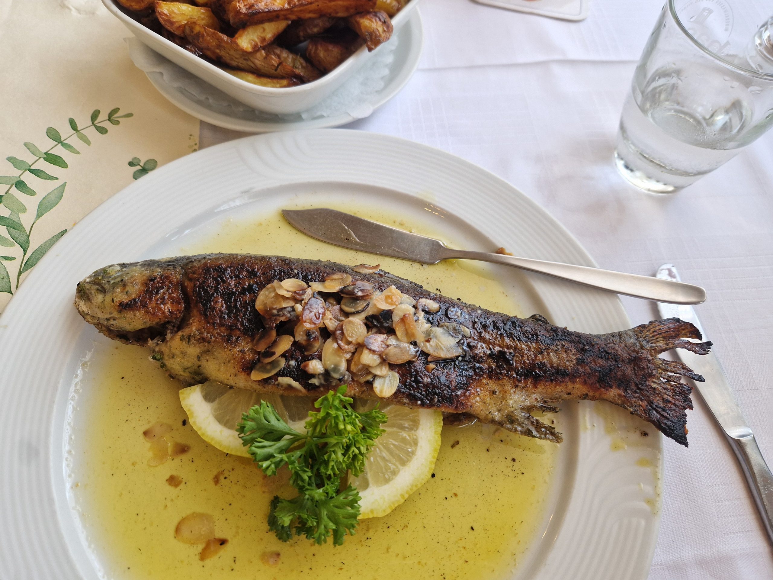 Whole pan-fried brown trout coated in toasted flaked almonds, served in a butter sauce with lemon and parsley